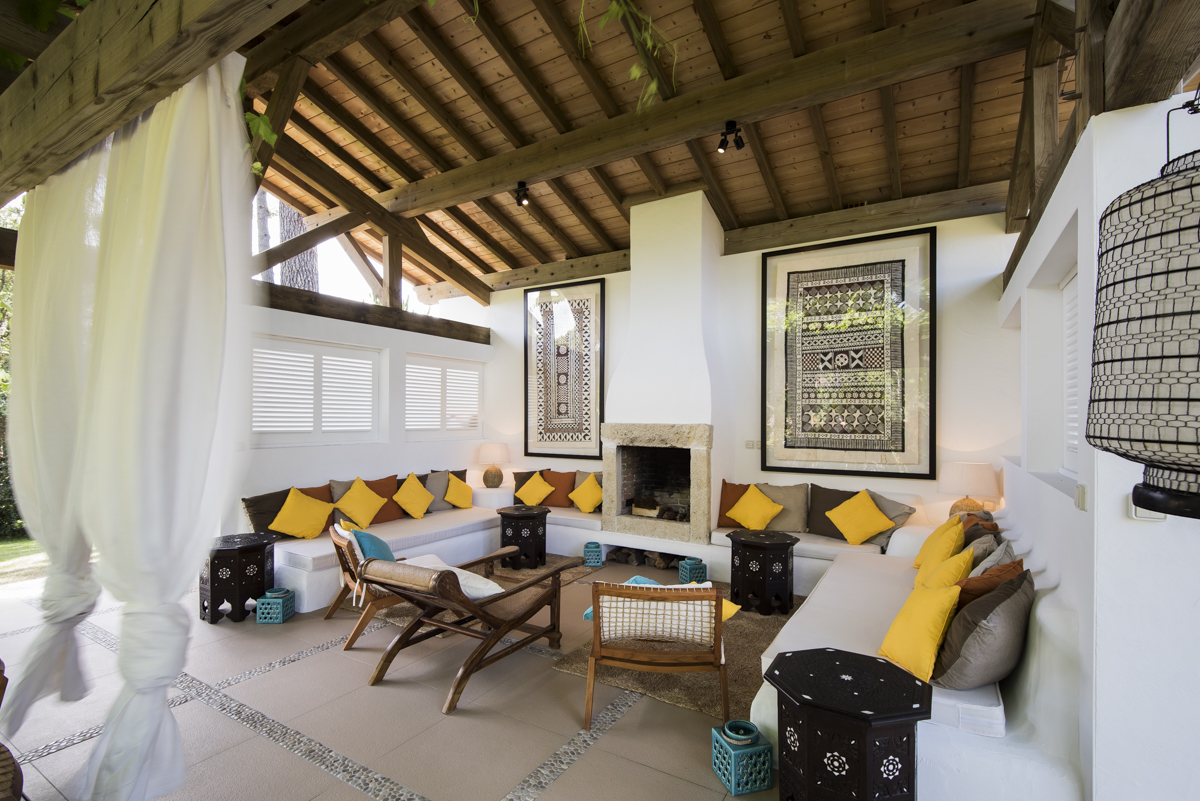 _MAR0717 The pool house was built around an open fireplace with deep seating, layers of lighting and curtains to add a cozy vibe for evenings by the fire.
