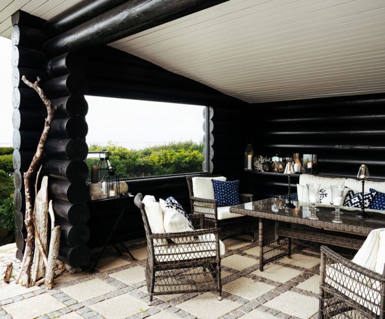 This Scandi outdoor cabin is furnished with pretty rattan looking outdoor furniture.