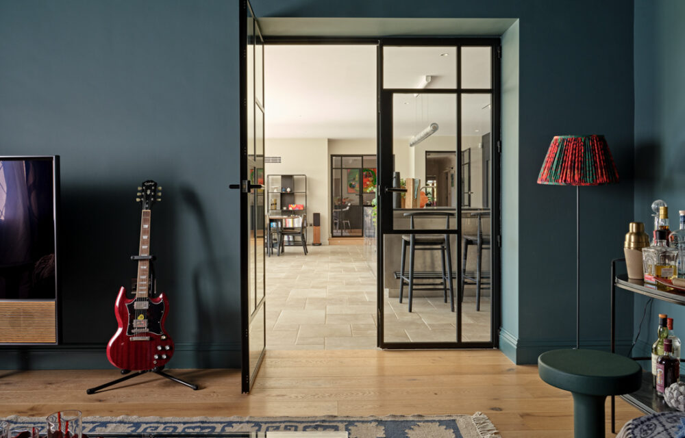 Modern Surrey country house , TV snug crittal doors leading to the kitchen extension